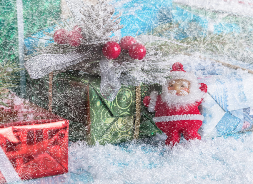 木头圣诞树枝和克劳斯雕像下面的礼品盒冬天圣诞节图片