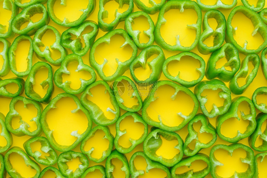 黄背景上切片生青胡椒的顶部视图黄背景上切片绿胡椒的顶部视图最佳生产成熟图片