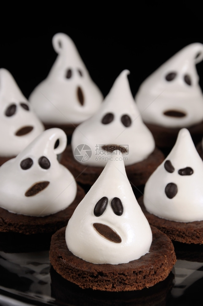 糕点作为万圣节的鬼魂巧克力饼干装饰和蛋白瓜内部的可口图片