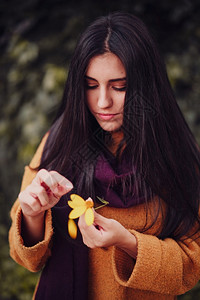 指甲场地年轻女在田里采黄色花朵肖像图片