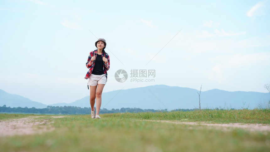 步行自由李亚洲青年女旅游客背包在自然林中徒步旅行以背景山地观视为自然的旅游女客图片