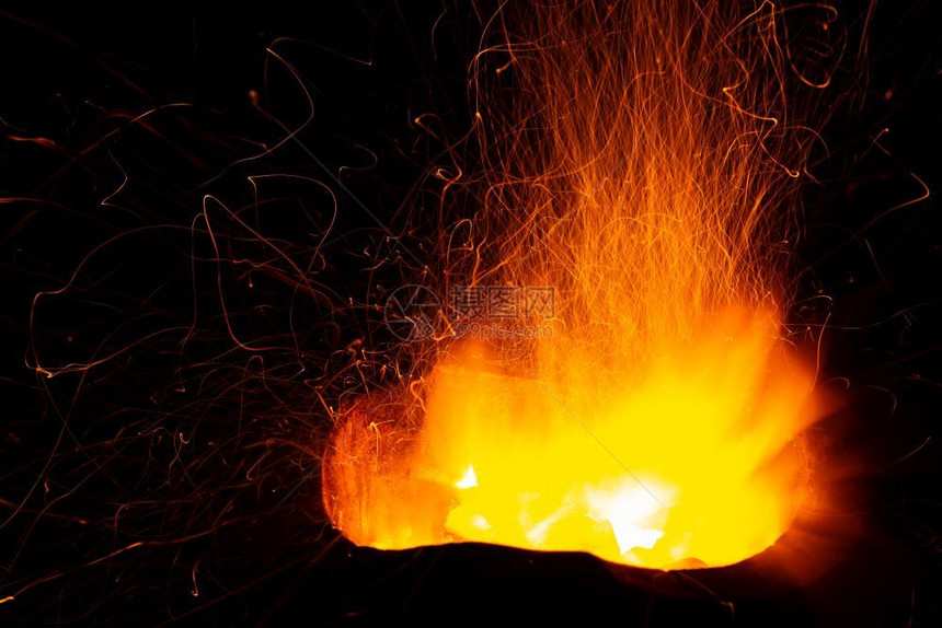 在黑暗背景下散布燃烧木炭的烈火抽象热图片