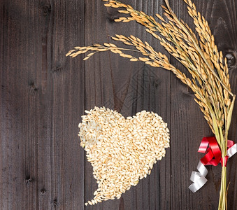 谷物农业玉米在照片中小麦耳和由木本底的稻谷形成心脏图片