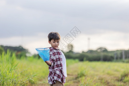 户外草地拿着昆虫网的小男孩图片