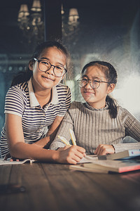 两个快乐的亚裔青少年在学校课堂习快乐的情绪幸福感趣坐着女士背景图片