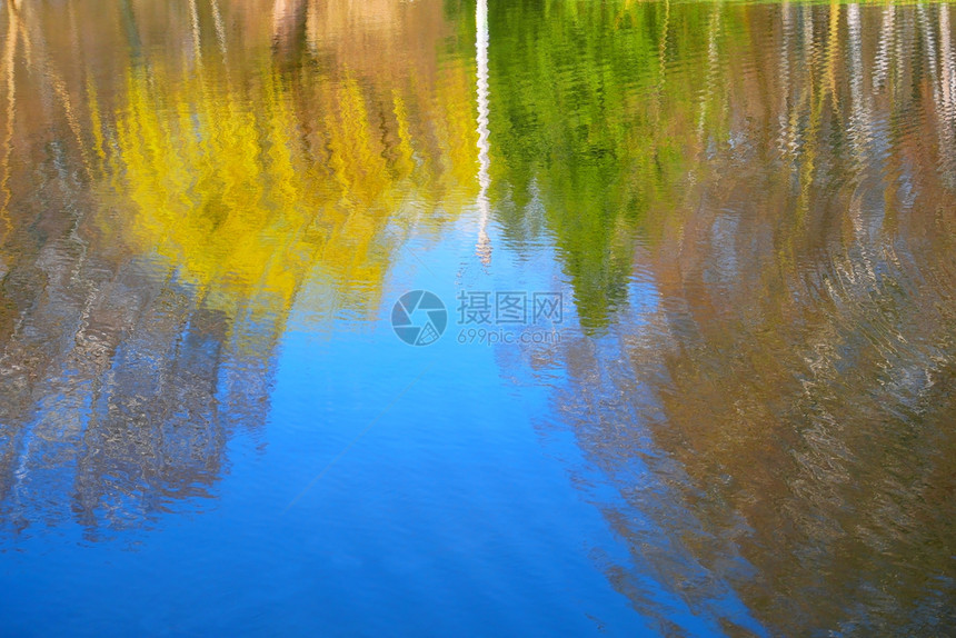 天气质地冷静的春时池塘表面反映波纹水中的天空树木和电源支持图片