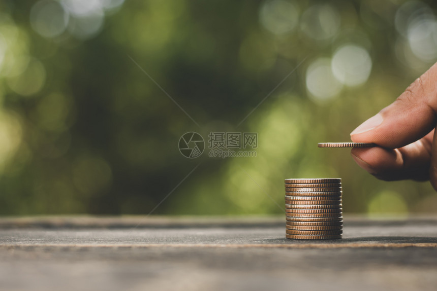 货币梦男人的手在对黑桌地板上堆叠的硬币进行分拣节省钱的概念保护图片
