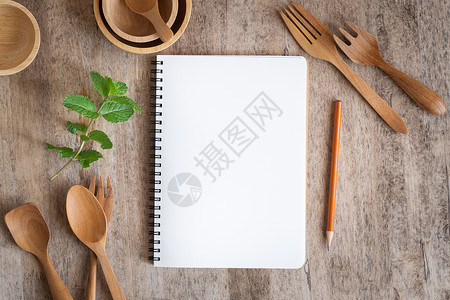 餐桌上的空白笔记本和木质餐具图片