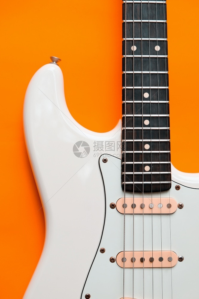 经典的橙色背景白电吉他详细信息播放器电的图片