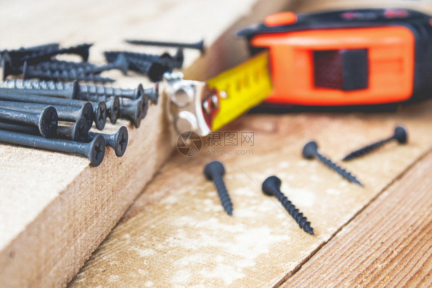 钻头木制的黑螺丝放在卷尺旁边的木板上工具和维修作的概念钢螺丝黑放在卷尺旁边的木板上工具和维修作的概念金属图片