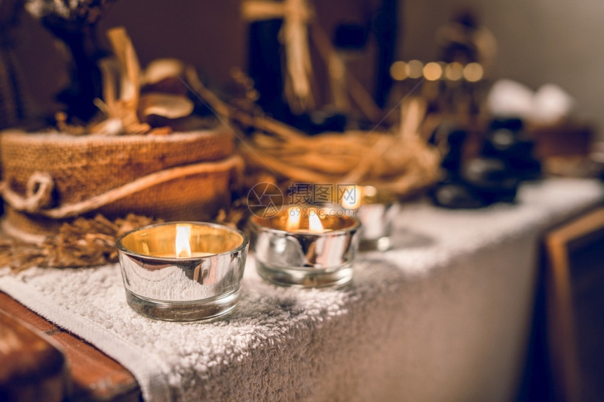 古装瓶和按摩巴萨勒特桌上的金宝石和蜡烛中的香油温泉药物有机的图片