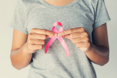 癌症早预防海报持有粉红丝带乳癌认识知概念保健和医学的手握血型术全球的粉色背景