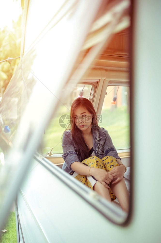 夏日坐在野营车里的美丽年轻女士房车面包旅游图片