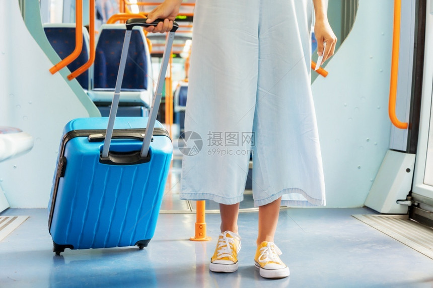 贴近一个举着手提箱的无法辨认女人搭火车旅行高品质照片贴近一个拿着手提箱无法识别的女人乘火车旅行不能辨认高的面目全非套装图片