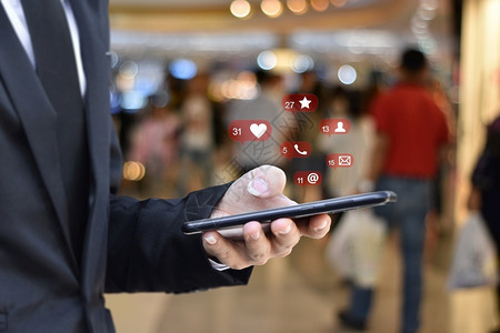 利用移动智能手机与社交媒体图标使用移动智能手机的商人关系密切机场站背景模糊商业技术或社交网络概念商业技术或社交网络概念信息电脑全背景图片