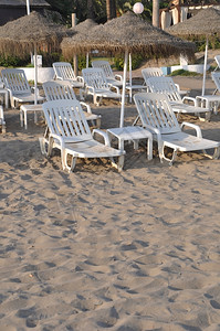 日落时海边的椅子和雨伞图片