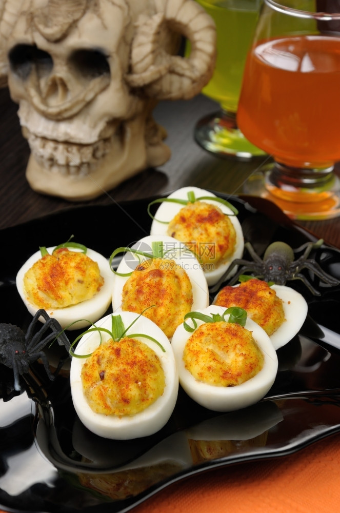 烹饪为纪念万圣节在假日餐桌上以南瓜形式填满的鸡蛋调味品餐巾图片