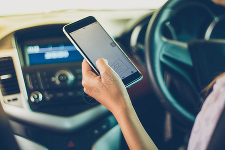 细胞坐着亚裔妇女在路上驾驶汽车使用智能手机在路上沟通互联网高清图片素材