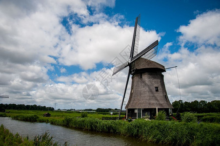乡村的传统河荷兰风车夏天有阴云的空图片
