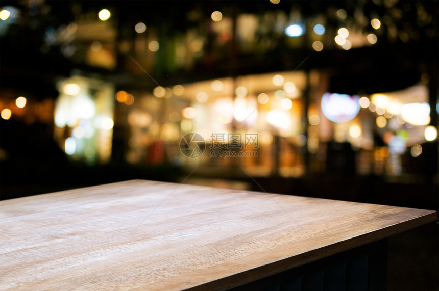 街道咖啡店正面在模糊的混合夜间市场前的空木桌bokeh背景图片