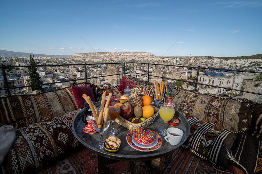 旅行品尝橄榄在土耳其卡帕多西亚戈雷梅市洞穴屋顶上与大风景盛的早餐图片