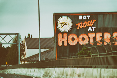 或者贸易海滩俄勒冈州波特兰2017年8月21日在高速公路上的Hooters标志是两家私人持有的美国连锁餐厅商品名俄勒冈州波特兰市背景图片