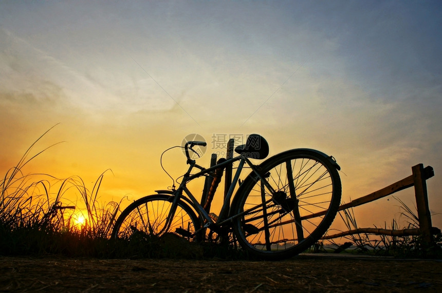 越南阳光美丽的自然景观在日出的乡村时将脚踏车停在木栅栏上给人以太阳和自行车轮椅的印象水平图片