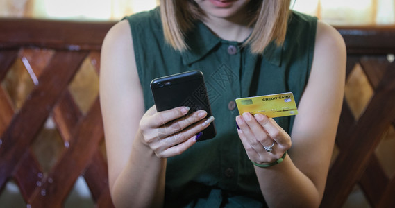 店铺支付在线使用智能手机和信卡购物的女亚洲电子商务无线的高清图片素材