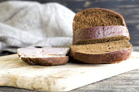 早餐脂肪备择方案切片黑麦面包上的肉香肠在厨房切片黑面包图片