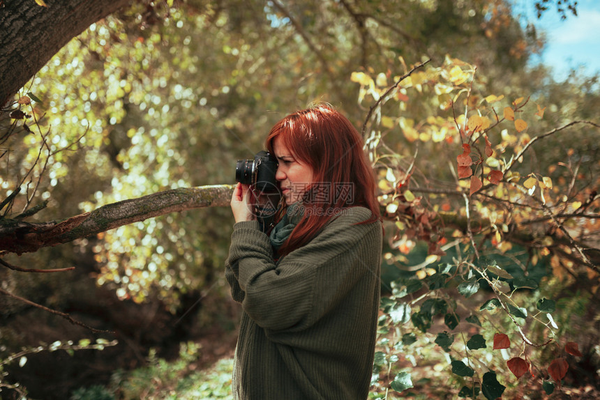 游客老的女孩年轻子用旧的模拟相机在森林里拍照图片