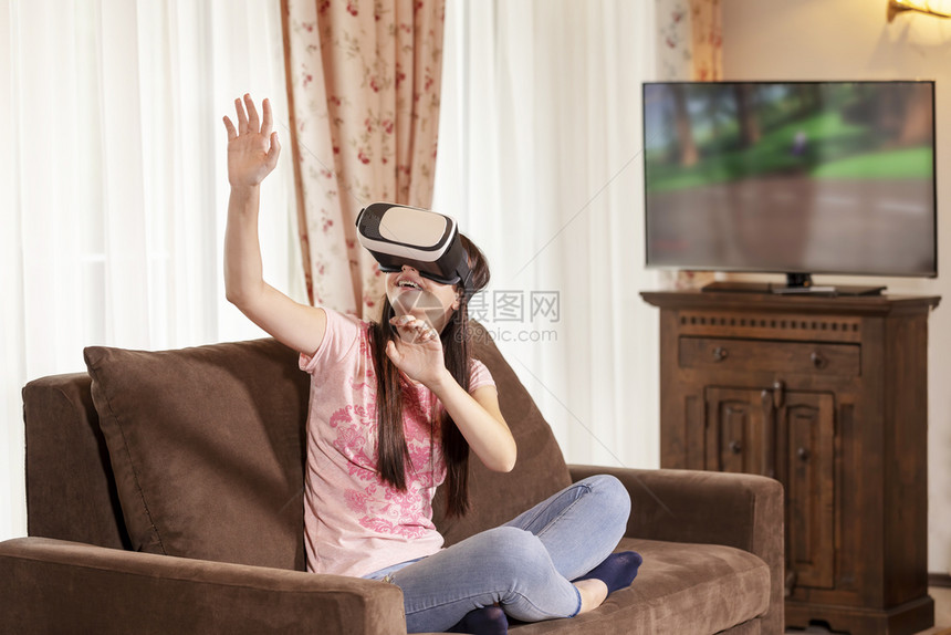 经验快乐的少女在家中与虚拟现实眼镜玩得开心的人和新技术概念并在人民和新技术的概念下使用虚拟现实眼镜观看模拟图片