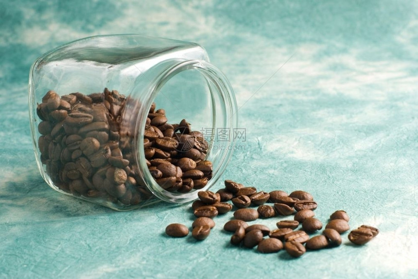 棕色的咖啡因用玻璃罐中的豆子有特殊反向背景贮存图片