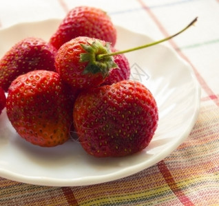 明亮的新鲜盘子上紧新鲜草莓放在白色盘子上的新鲜草莓多汁图片