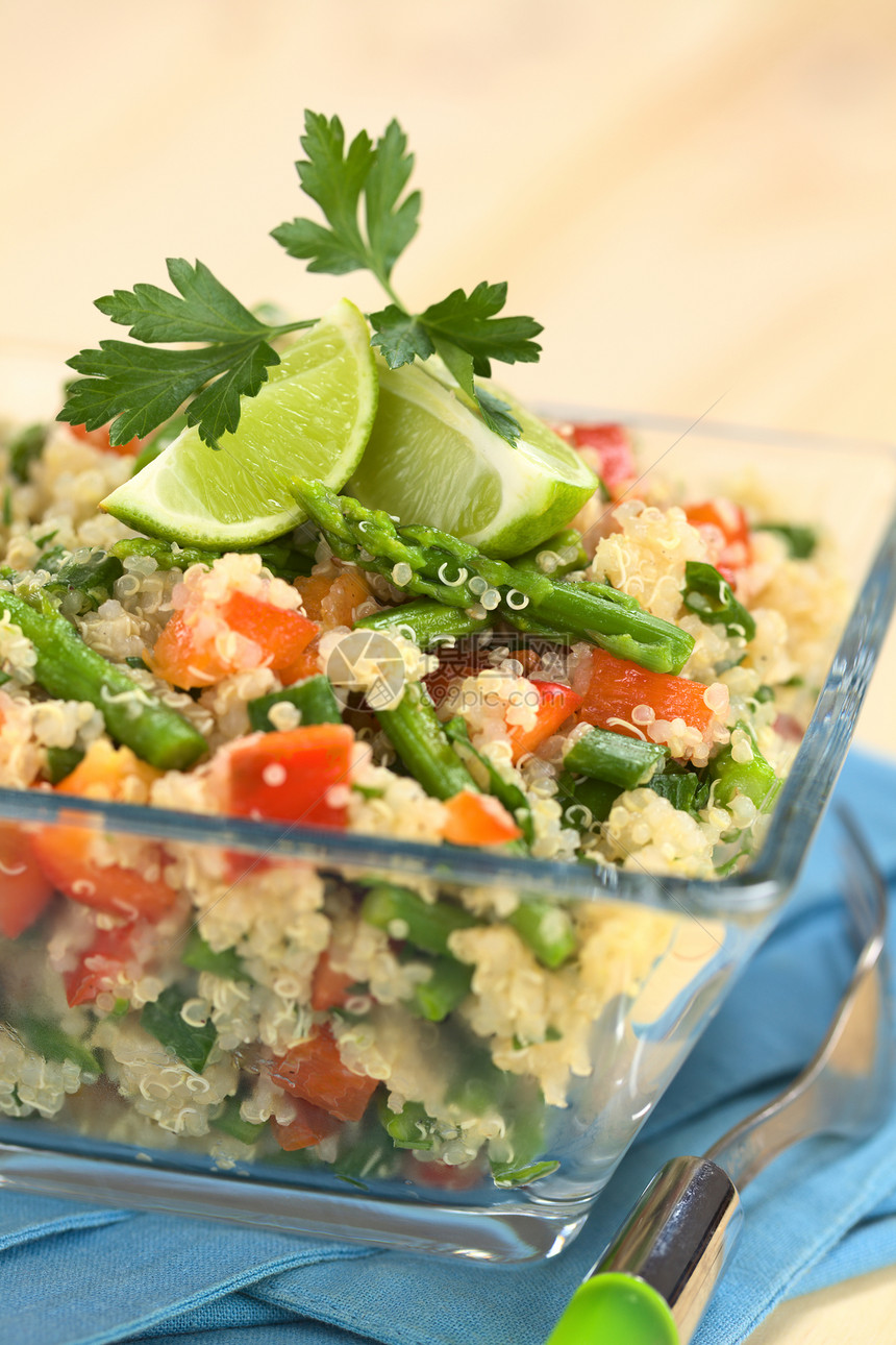 滋补香菜蔬quinoa配有绿色的鹦鹉和红胡椒加满了石灰和面橘叶在玻璃碗中供餐选择焦点关注盘子上的羊头午餐图片