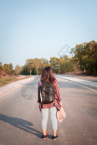 白色的带背在沥青路农村地区行走的女旅妇自然徒步旅行图片