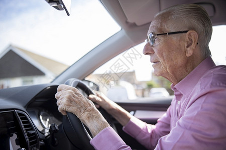 户外由汽车挡风玻璃看的担心老年男驾驶员八十代司机图片
