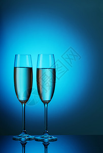 两杯水晶子香槟放在蓝色背景上香槟玻璃泡沫红酒杯图片
