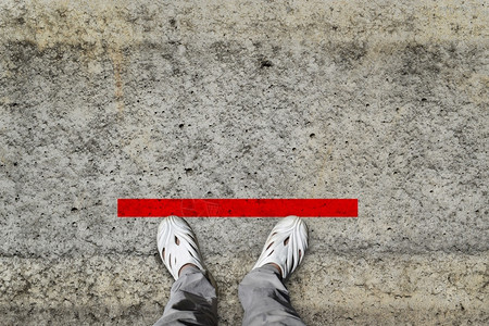 脚印男人上下的顶部站立在红线上公共空间概念的地板上练习社交间距会的图片