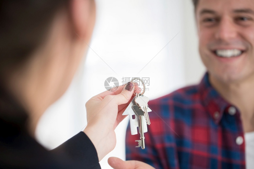 男人从女房地产商收集到新家的密钥房地产经纪人新的购买图片