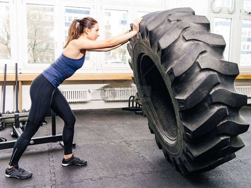照片来自一位有吸引力的年轻女子在交叉体操A与拖拉机轮胎一起工作重量白种人健康图片