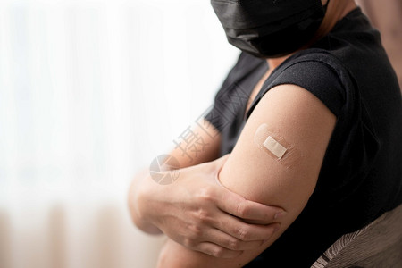 注射疫苗后佩戴口罩的男子将手臂露出背景图片