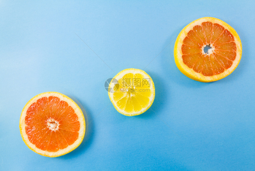 复制空间蓝色背景下一粒柠檬和两片葡萄果切的顶部视图带复制文本空间的最小化图片风格热带黄色的图片