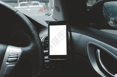 展示汽车空气喷口的移动电话与白色屏幕隔开在汽车里装上智能手机收费复制图片