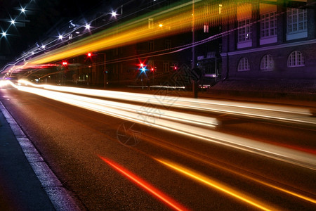 发光的快速地夜里城市交通的光束发出芒大灯图片