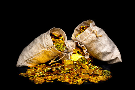 保险箱加金币宝藏收益黑背景的宝袋中堆积金币叠背景