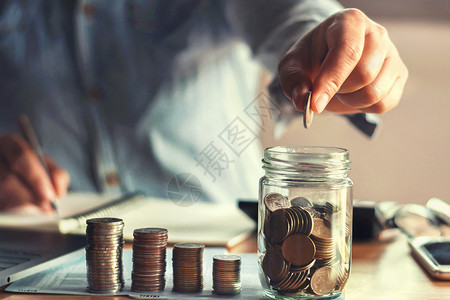 节省债务成人储蓄钱用手把硬币放在玻璃杯中金融概念收益高清图片素材