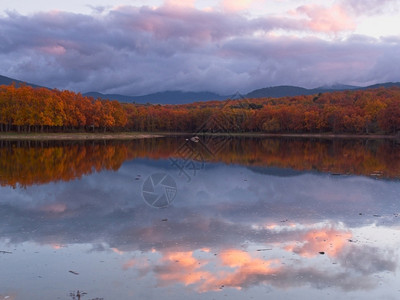 树叶日落秋天黄昏的湖风景反射和云彩暮图片