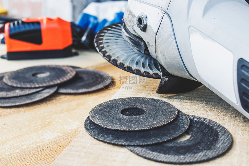 车轮角磨机的圆在床附近木板上角磨机的工具和维修作圈的概念在磨床附近的木板上力量保护图片