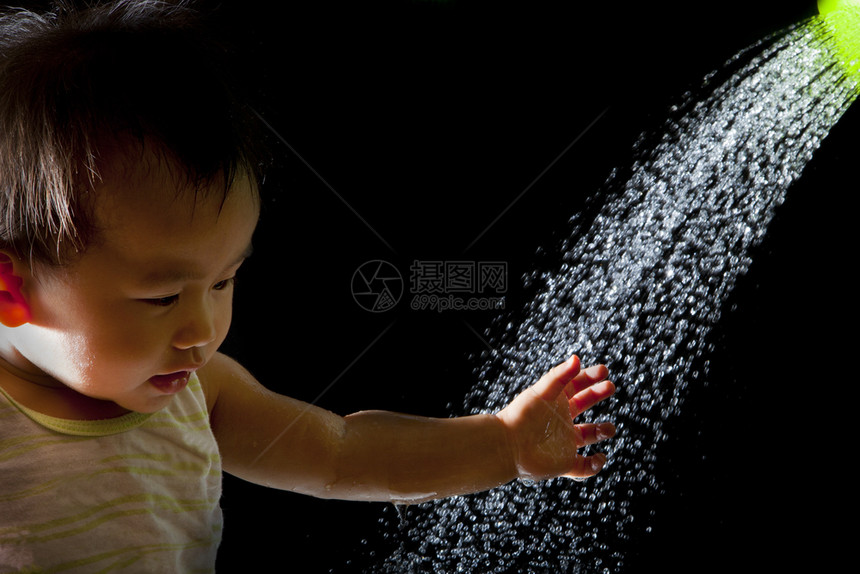 喜悦幸福亚洲婴儿在黑色背景上玩水的脸文件亚洲婴儿在黑色背景上玩水的脸夏天图片