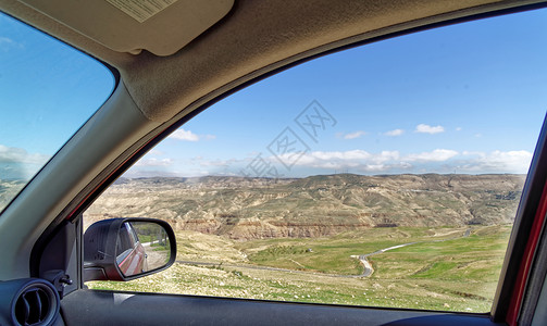 门从一辆出租汽车的窗口到约旦中东部Dana生物圈保留地边缘达纳生物圈保护区镜子里面背景